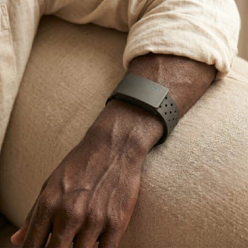 Macro close-up of the BaroShift armband on a forearm in warm natural light