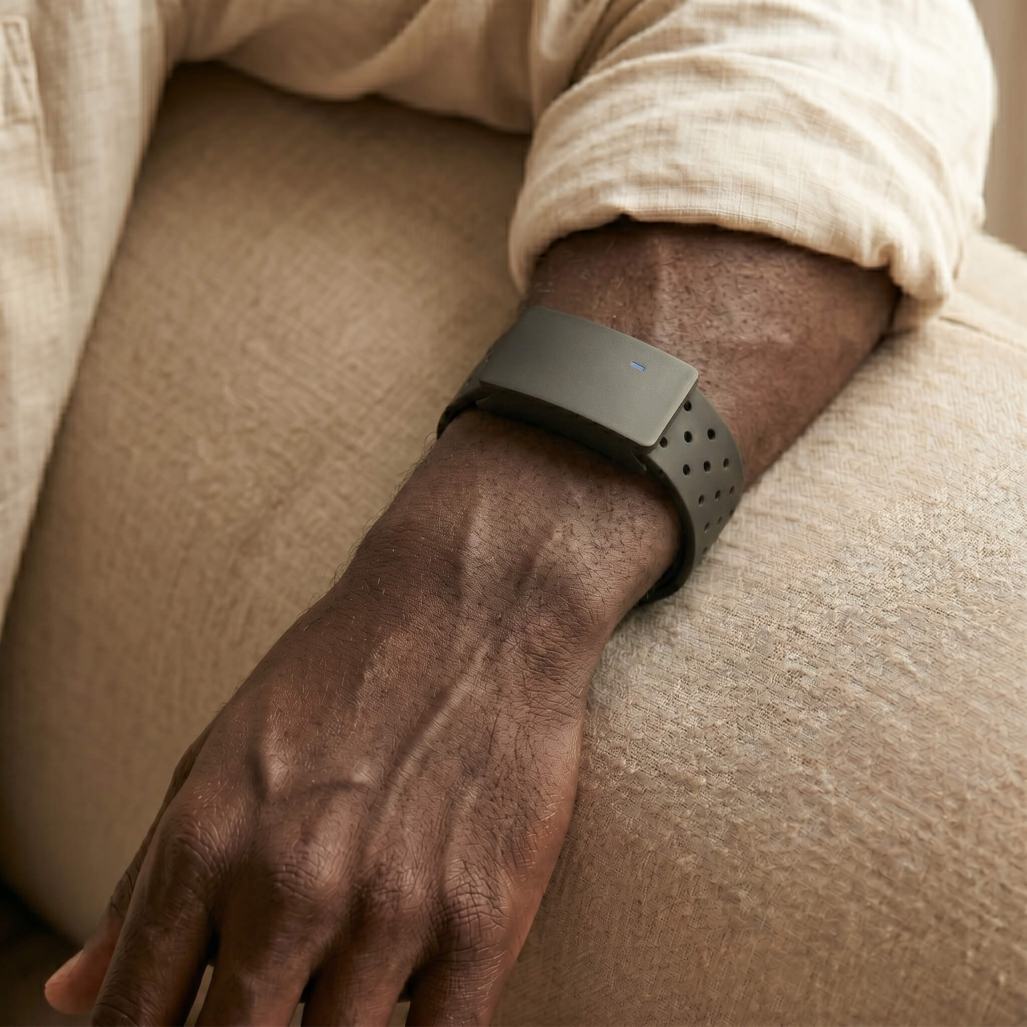 Macro close-up of the BaroShift armband on a forearm in warm natural light